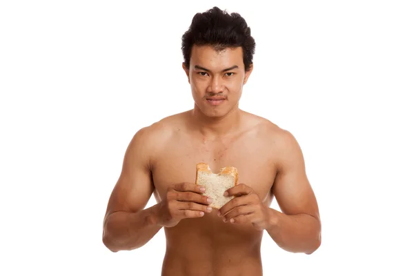 Musculoso asiático hombre carga carbohidratos comer algunos pan — Foto de Stock