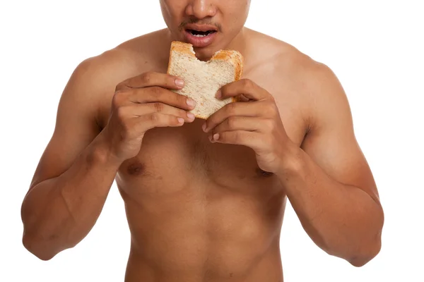 Musculoso asiático hombre carga carbohidratos comer algunos pan — Foto de Stock