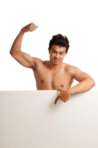 Muscular Asian man point down  flexing biceps behind  blank sign — Stock Photo, Image