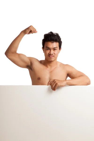 Muscular asiático homem flexionando bíceps atrás de sinal em branco — Fotografia de Stock