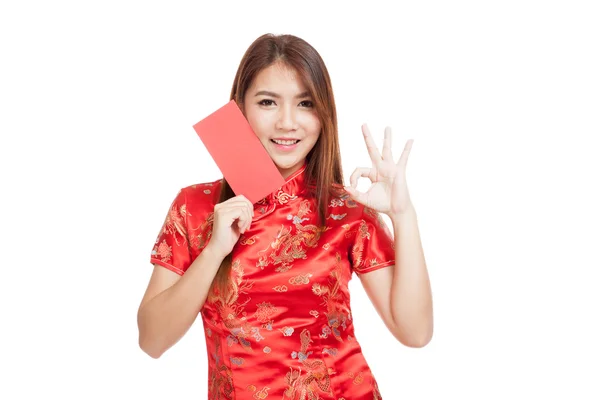 Asijská dívka v šatech čínských cheongsam Ukázat Ok s červenou obálku — Stock fotografie
