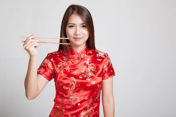 Азиатка в китайском платье из чхонсам с палочками для еды — стоковое фото