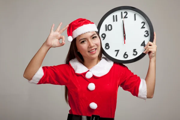 Азиатская рождественская девушка в одежде Санта-Клауса и часах в полночь — стоковое фото