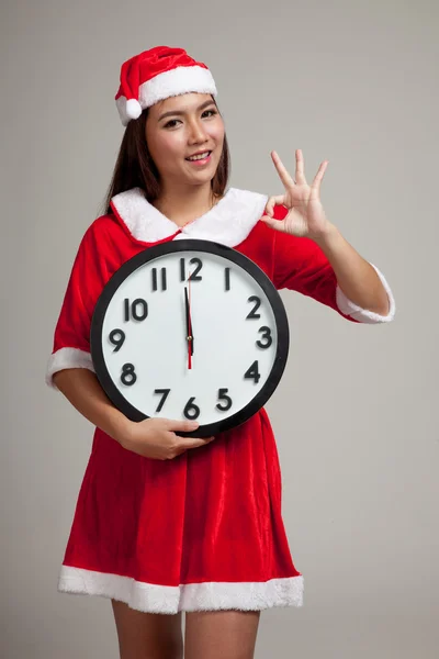 Asian Christmas girl in Santa Claus clothes and clock at midnigh — Stock Photo, Image
