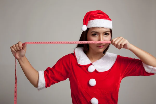 Menina asiática de Natal em Papai Noel roupas dieta com medição — Fotografia de Stock