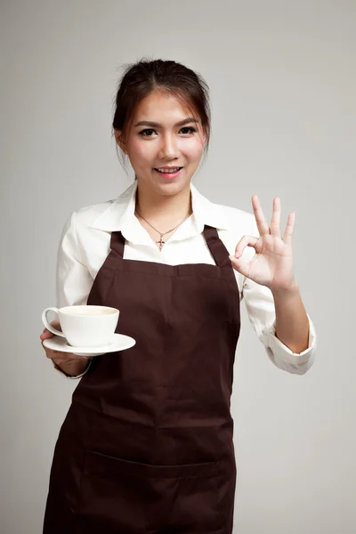 Servitør eller barista i forkle med kaffe i hånden – stockfoto