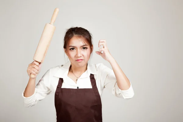 Asiatische Bäckerin in Schürze mit hölzernem Nudelholz — Stockfoto