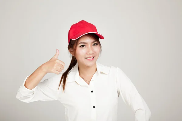 快乐的亚洲女孩竖起大拇指与顶红色的帽子 — 图库照片