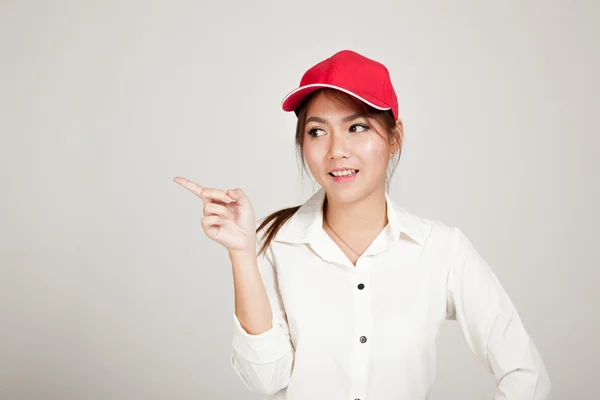 Feliz asiática chica con rojo sombrero punto a espacio en blanco —  Fotos de Stock