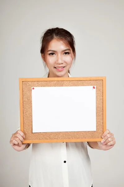 Asiatisk tjej med blankt papper pin på kork ombord — Stockfoto