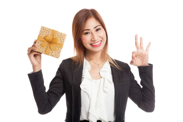 Young Asian business woman show OK with a golden gift box — Stock Photo, Image