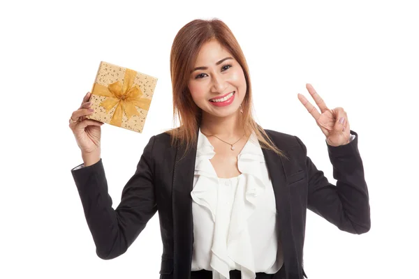 Mujer de negocios asiática muestra signo de victoria con una caja de regalo de oro — Foto de Stock