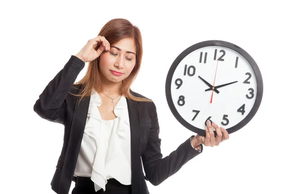 Sleepy young Asian business woman with a clock in the morning — Stock Photo, Image