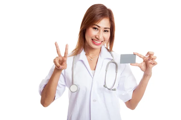 Asiática joven médico mostrar signo de victoria con tarjeta en blanco — Foto de Stock