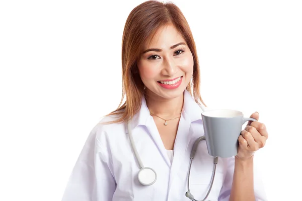 Молодая азиатка-врач держит кружку и улыбается — стоковое фото