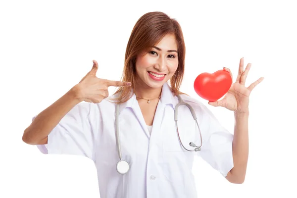 Junge asiatische Ärztin zeigt auf rotes Herz — Stockfoto