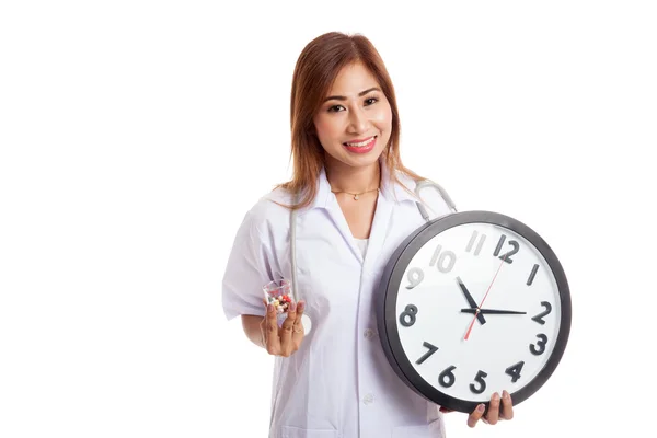 Young Asian female doctor smile with a clock and pills — Stock Photo, Image