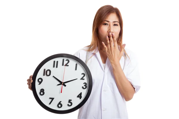 Jeune asiatique femme médecin bâiller avec une horloge — Photo