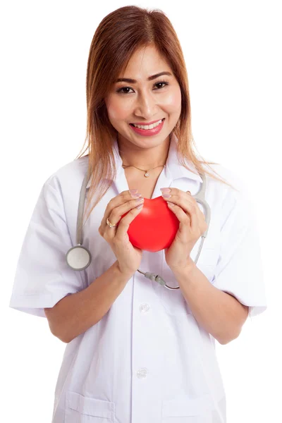 Aziatische jonge vrouwelijke arts houden een rood hart en glimlach — Stockfoto