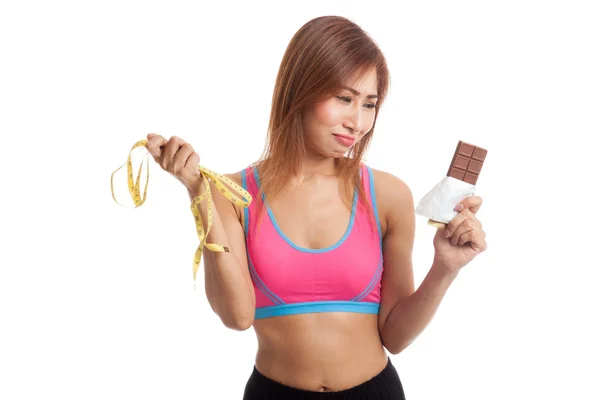 Infeliz asiática sana chica con chocolate y cinta métrica —  Fotos de Stock