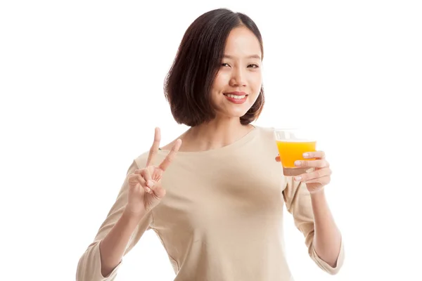 Junge asiatische Frau zeigt Siegeszeichen trinken Orangensaft — Stockfoto