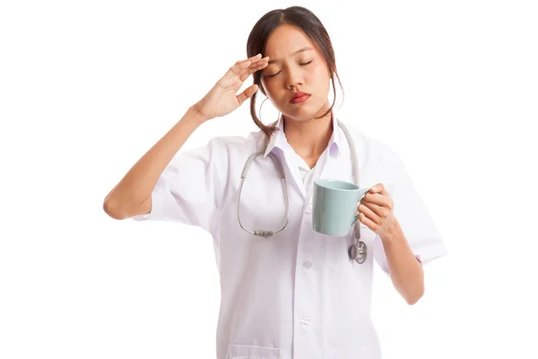 Asiatische junge Ärztin bekam Kopfschmerzen mit einer Tasse Kaffee — Stockfoto