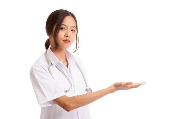 Молодая азиатка-врач представляет что-то слева. — стоковое фото