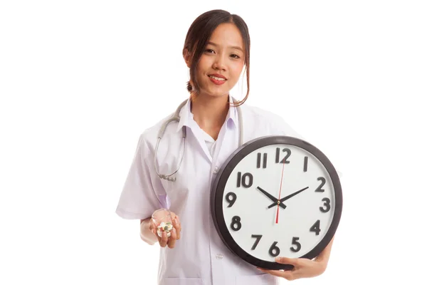 Uśmiech młodych azjatyckich kobiet lekarza z zegarem i pigułki — Zdjęcie stockowe