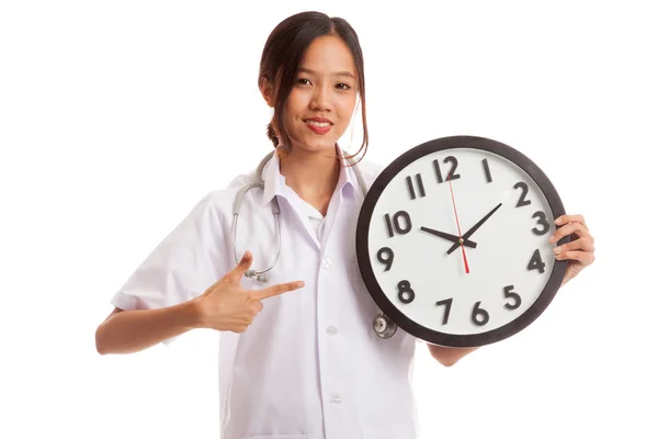 Joven asiática mujer médico punto a un reloj —  Fotos de Stock