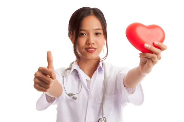Молодая азиатская медсестра поднимает большие пальцы с красным сердцем — стоковое фото