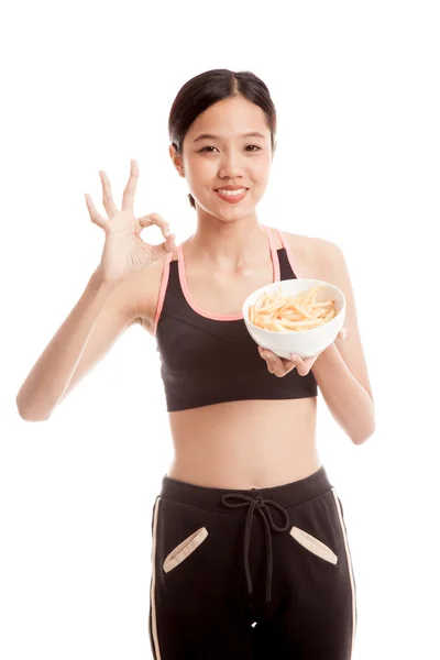 Asiática sana chica comer papas fritas show OK signo — Foto de Stock