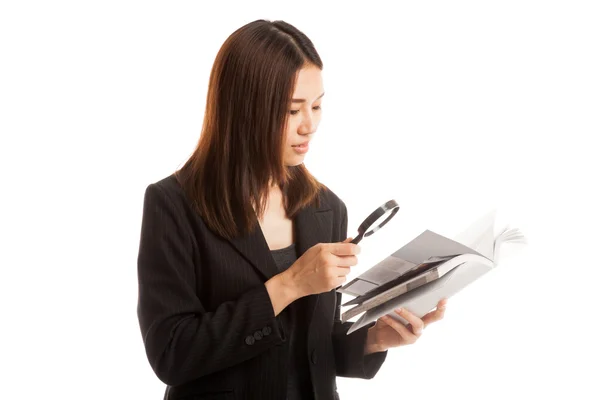 Aziatische zakenvrouw met een boek en vergrootglas. — Stockfoto