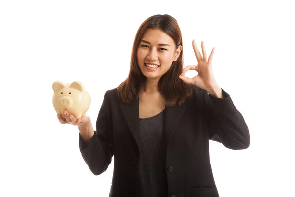 Asiática mujer de negocios show OK con cerdo moneda banco . — Foto de Stock