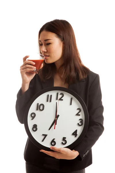 Jeune femme d'affaires asiatique avec jus de tomate et horloge . — Photo