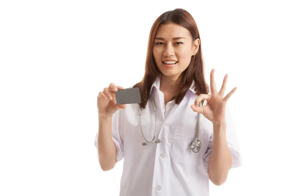 Asiatische junge Ärztin zeigen ok Zeichen mit leere Karte. — Stockfoto