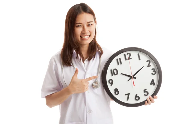 Joven asiática mujer médico punto a un reloj . — Foto de Stock