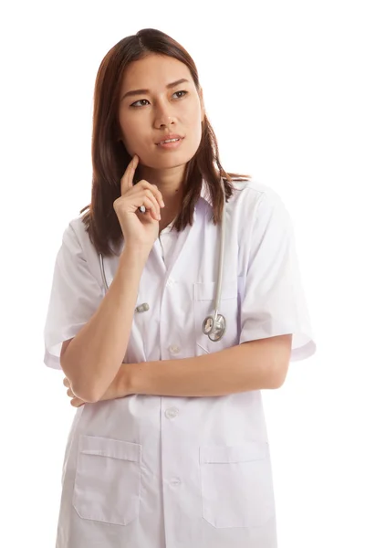 Молодая азиатка-врач думает, глядя вверх . — стоковое фото