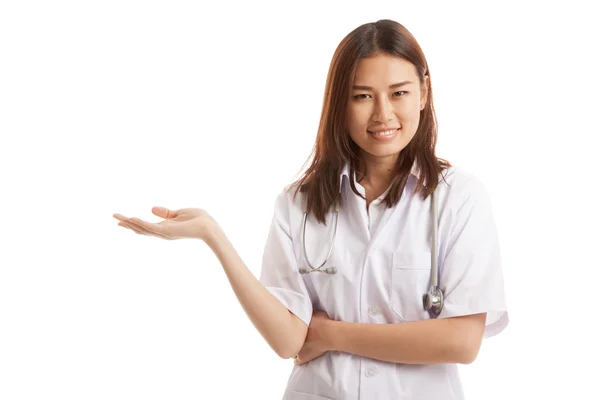 Asiática joven médico muestra algo en su mano . —  Fotos de Stock