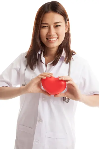 Asiática joven médico sostiene un corazón rojo y sonrisa . — Foto de Stock