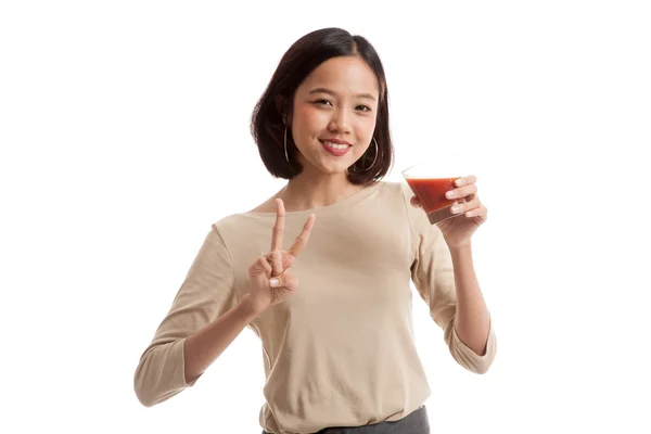Asiatico donna spettacolo vittoria segno con pomodoro succo — Foto Stock