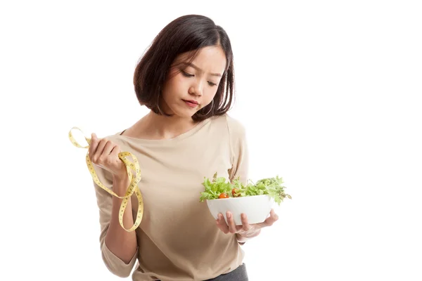 Несчастная азиатская деловая женщина с измерительной лентой и салатом — стоковое фото
