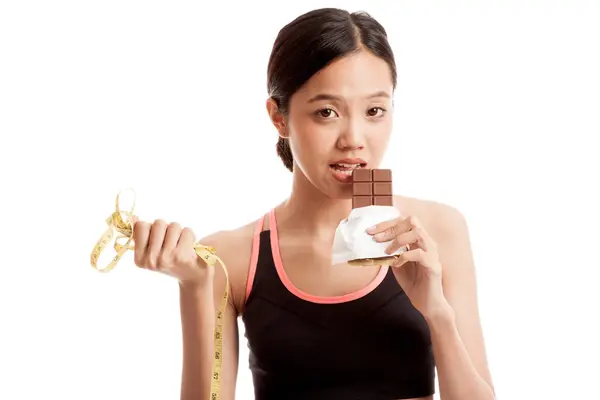 Красивая азиатская здоровая девушка с шоколадом и измерительной лентой — стоковое фото