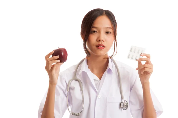 Unga asiatiska kvinnliga läkare med piller och äpple — Stockfoto
