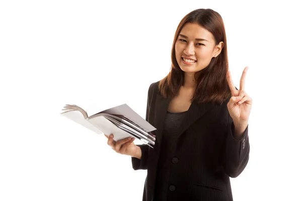 Unga asiatiska affärskvinna Visa victor tecken med en bok. — Stockfoto