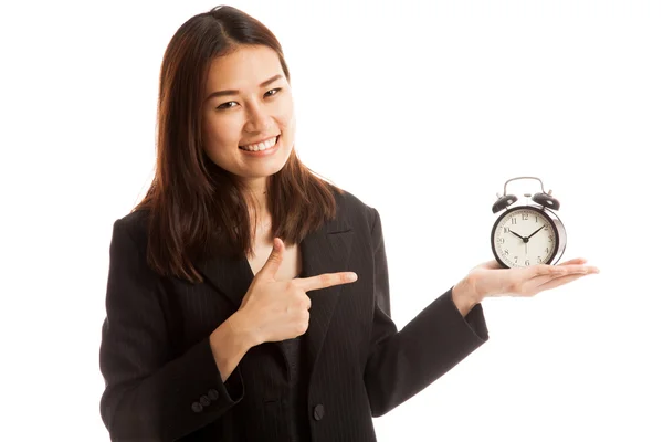 Jeune femme d'affaires asiatique pointent vers une horloge . — Photo
