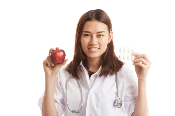 Jeune asiatique femme médecin avec des pilules et de la pomme . — Photo