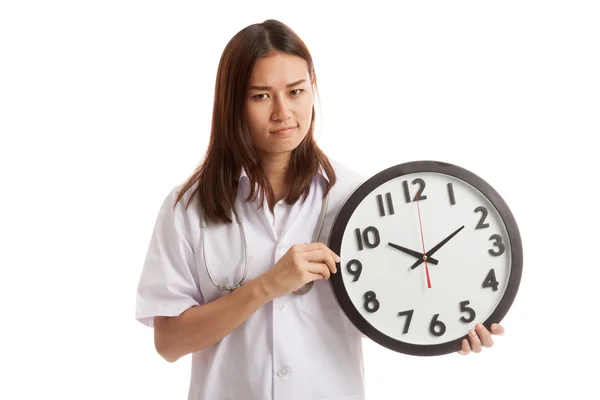 Frustré jeune asiatique femme médecin avec une horloge . — Photo