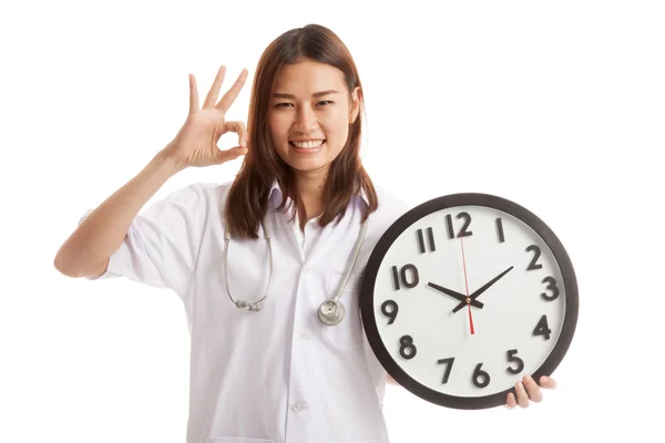 Junge asiatische weibliche Arzt zeigen ok mit ein Uhr. — Stockfoto