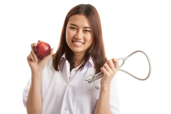 Junge asiatische Ärztin halten Apfel und Stethoskop. — Stockfoto