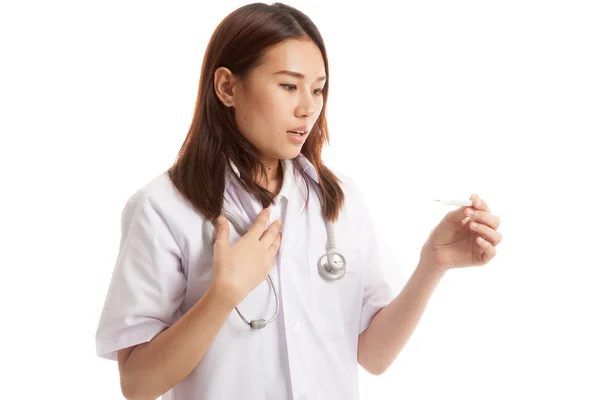 Junge asiatische Ärztin besorgt Blick auf Thermometer. — Stockfoto